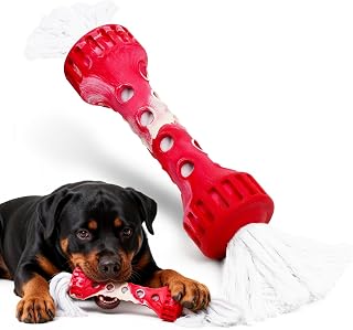 Red heavy-duty rubber chew bone with white rope ends being chewed by a Rottweiler